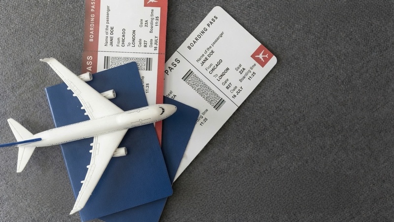 Miniature airplane model placed on travel passports with airline boarding passes representing TTweakFlight offers and flight booking guides